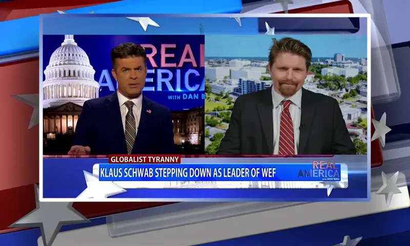 Video still from Real America on One America News Network showing a split screen of the host on the left side, and on the right side is the guest, Seamus Bruner.