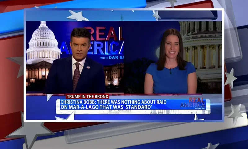 Video still from Real America on One America News Network showing a split screen of the host on the left side, and on the right side is the guest, Christina Bobb.
