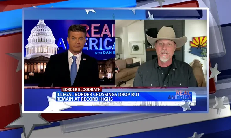 Video still from Real America on One America News Network showing a split screen of the host on the left side, and on the right side is the guest, Sheriff Mark Lamb.