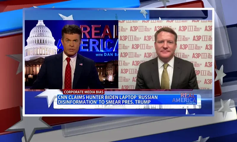 Video still from Real America on One America News Network showing a split screen of the host on the left side, and on the right side is the guest, Mike Davis.