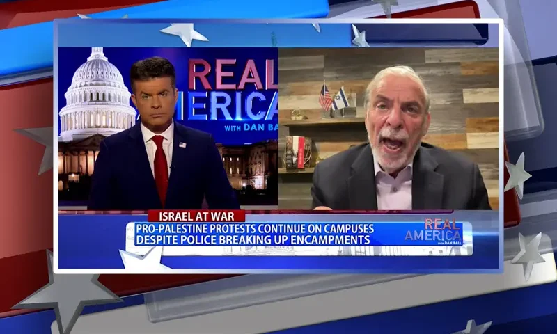 Video still from Real America on One America News Network showing a split screen of the host on the left side, and on the right side is the guest, Dov Hikind.