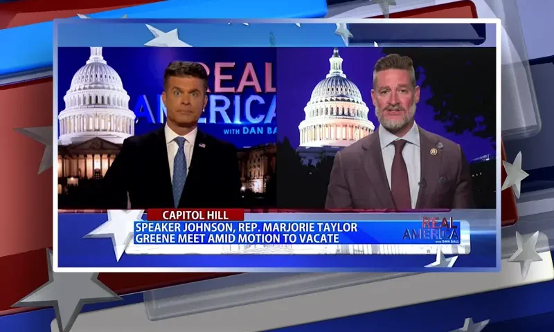 Video still from Real America on One America News Network showing a split screen of the host on the left side, and on the right side is the guest, Rep. Greg Steube.