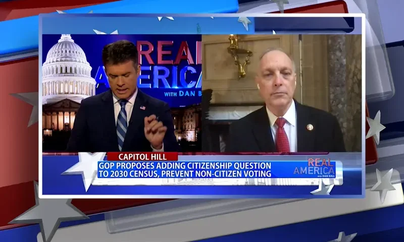 Video still from Real America on One America News Network showing a split screen of the host on the left side, and on the right side is the guest, Rep. Andy Biggs.