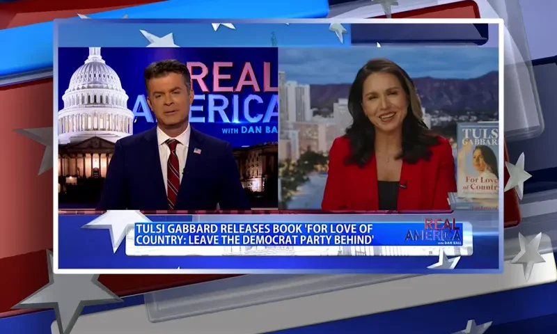 Video still from Real America on One America News Network showing a split screen of the host on the left side, and on the right side is the guest, Tulsi Gabbard.