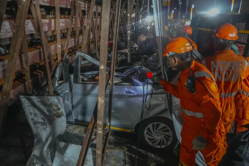 Rescuers look for victims under a billboard that collapsed following heavy rain and thundershowers in Mumbai, India, Monday, May 13, 2024. Scores of people were thought to be trapped after the collapse in the suburb of Ghatkopar, Mumbai police said on social media platform X. (AP Photo/Rafiq Maqbool)