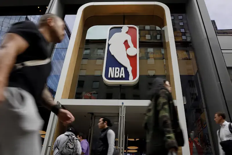The NBA logo is displayed as people pass by the NBA Store in New York City, U.S., October 7, 2019. REUTERS/Brendan McDermid/File Photo