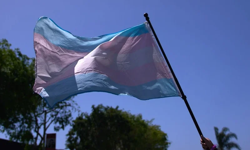 A Transgender Pride Flag is held above the crowd of LGBTQ+ activists during the Los Angeles LGBT Center's "Drag March LA: The March on Santa Monica Boulevard", in West Hollywood, California, on Easter Sunday April 9, 2023. The march comes in response to more than 400 pieces of legislation targeting the LGBTQ+ community that government officials across the United States have proposed or passed in 2023. (Photo by ALLISON DINNER / AFP) (Photo by ALLISON DINNER/AFP via Getty Images)
