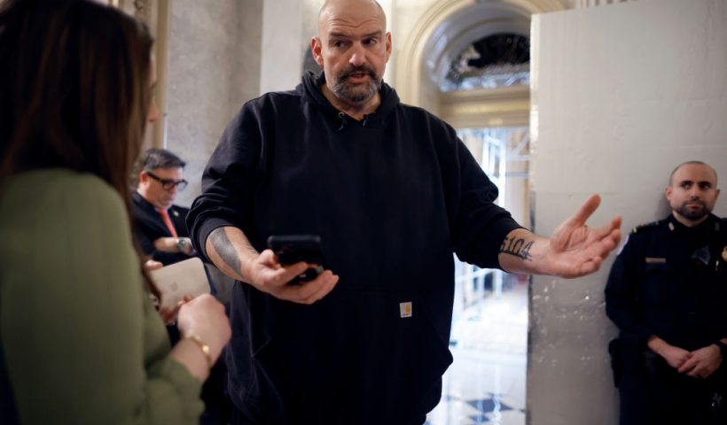 WASHINGTON, DC - FEBRUARY 12: Sen. John Fetterman (D-PA) uses a speech-to-text app on his iPhone to better understand a reporter's questions in between votes at the U.S. Capitol on February 12, 2024 in Washington, DC. Following a series of evening votes, the Senate will stay in session all night with the goal of passing national security legislation that would send $95 billion in military aid to Ukraine, Israel and Taiwan. (Photo by Chip Somodevilla/Getty Images)