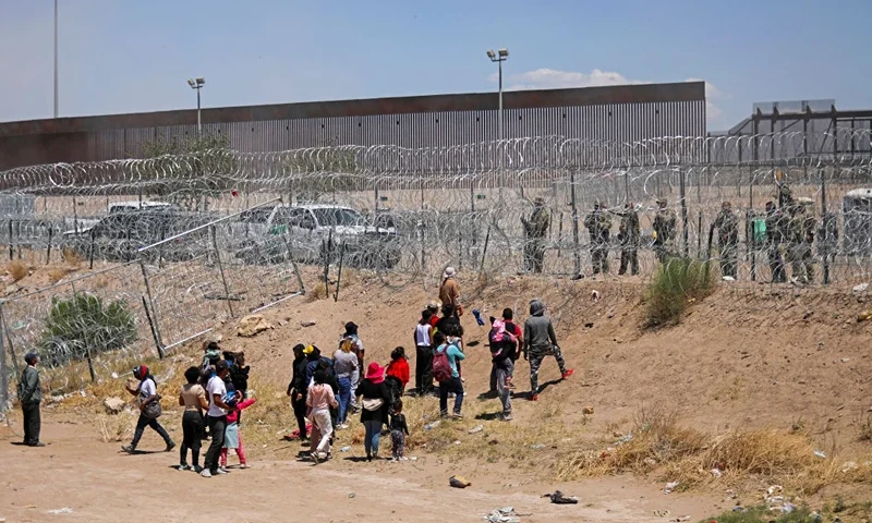 Migrants attempting to enter the United States through a barbed wire fence installed along the Rio Grande River are chased away with tear gas by Texas National Guard agents at the border with Ciudad Juarez, Chihuahua State, Mexico, on May 13, 2024. (Photo by HERIKA MARTINEZ / AFP) (Photo by HERIKA MARTINEZ/AFP via Getty Images)