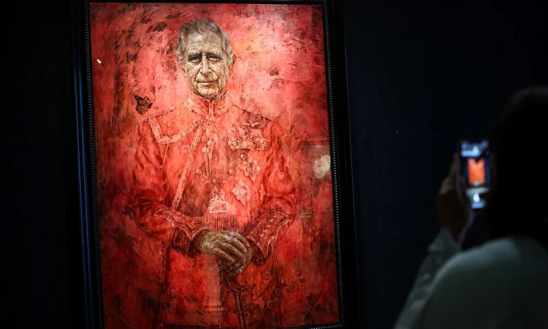 A visitor takes a picture with a mobile phone of the new official portrait of King Charles III, painted by British artist Jonathan Yeo, displayed at the Philip Mould gallery, on Pall Mall, central London, on May 16, 2024 following its official unveiling two days ago at Buckingham Palace. The official portrait was commissioned in 2020 to celebrate the then Prince of Wales's 50 years as a member of The Drapers' Company in 2022. Artist Jonathan Yeo had four sittings with the King Charles III, beginning when he was Prince of Wales in June 2021 at Highgrove, and later at Clarence House. The last sitting took place in November 2023 at Clarence House. Yeo also worked from drawings and photography he took, allowing him to work on the portrait in his London studio between sittings. The canvas size - approximately 8.5 by 6.5 feet when framed - was carefully considered to fit within the architecture of Drapers' Hall and the context of the paintings it will eventually hang alongside. (Photo by HENRY NICHOLLS / AFP) / RESTRICTED TO EDITORIAL USE - MANDATORY MENTION OF THE ARTIST UPON PUBLICATION - TO ILLUSTRATE THE EVENT AS SPECIFIED IN THE CAPTION (Photo by HENRY NICHOLLS/AFP via Getty Images)