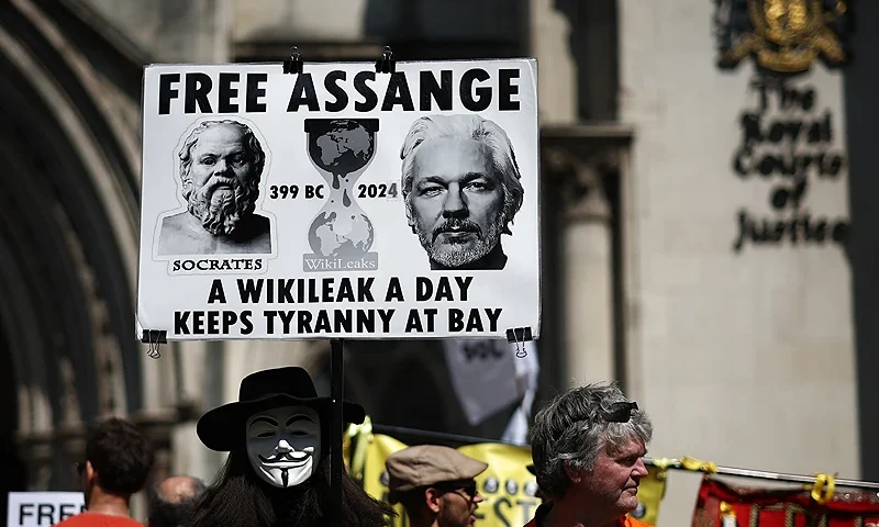 Supporters of WikiLeaks founder Julian Assange hold banners and placards as they protest in support of him, outside The Royal Courts of Justice, Britain's High Court, in central London on May 20, 2024. WikiLeaks founder Julian Assange could find out on Monday whether he has won a reprieve in his last-ditch UK legal battle to avoid extradition to the United States. (Photo by HENRY NICHOLLS / AFP) (Photo by HENRY NICHOLLS/AFP via Getty Images)