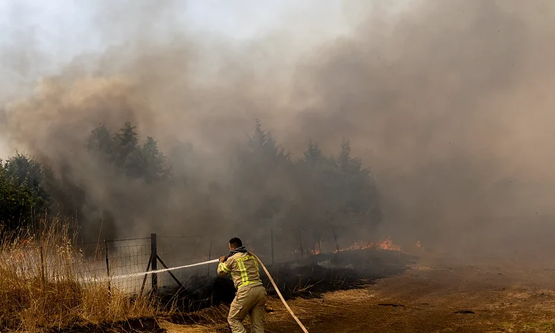 GOLAN HEIGHTS - JUNE 13: A firefighter responds to a fire break out after a Hezbollah rocket attack on Northern Israel on June 13, 2024 in Golan Heights, Unspecified. A series of fires have broken out in the area recently following rocket strikes by Hezbollah, the militant and political group based across Israel's northern border in Lebanon. (Photo by Amir Levy/Getty Images)
