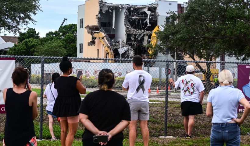 People watch as crews begin to demolish the building where seventeen people were killed during the 2018 mass shooting at Marjory Stoneman Douglas High School in Parkland, Florida, on June 14, 2024. Seventeen people were killed and another seventeen were injured after a 19-year-old former student opened fire at the school on February 14, 2018. (Photo by GIORGIO VIERA / AFP) (Photo by GIORGIO VIERA/AFP via Getty Images)
