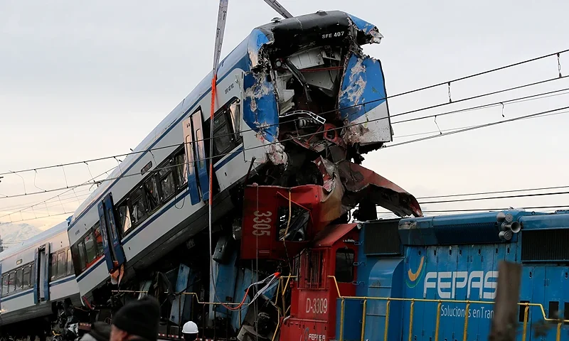 A crane lifts one of the two trains that collided in the commune of San Bernardo, in Santiago on June 20, 2024. Two people were killed and several injured following the head-on collision between a goods train and a test train early in the morning on the outskirts of Chile's capital, the railway company reported. (Photo by Javier TORRES / AFP) (Photo by JAVIER TORRES/AFP via Getty Images)