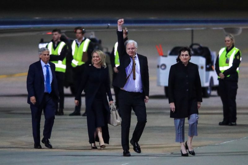 CANBERRA, AUSTRALIA - JUNE 26: WikiLeaks founder Julian Assange (C) gestures as he arrives at Canberra Airport on June 26, 2024 in Canberra, Australia. Julian Assange, the WikiLeaks founder, returned to his native Australia as a free man, after attending the U.S. District Court for the Northern Mariana Islands in Saipan on Wednesday. Following his guilty plea to a felony charge under the Espionage Act, Assange was sentenced to time served and subsequently released, allowing him to walk free after years of incarceration and intense lobbying for his release from across the political spectrum. Family, supporters and politicians welcomed his release and return, with Australia's Prime Minister Anthony Albanese saying the case