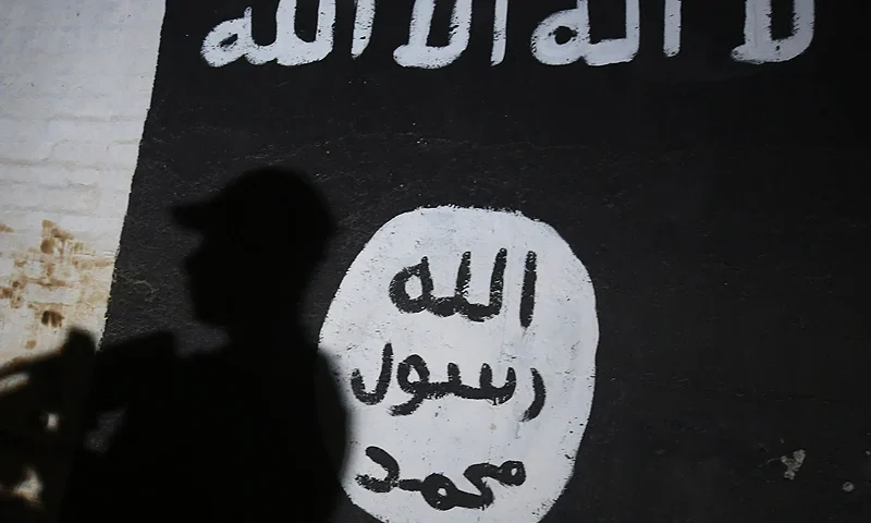 TOPSHOT - A member of the Iraqi forces walks past a mural bearing the logo of the Islamic State (IS) group in a tunnel that was reportedly used as a training centre by the jihadists, on March 1, 2017, in the village of Albu Sayf, on the southern outskirts of Mosul. Iraqi forces launched a major push on February 19 to recapture the west of Mosul from the Islamic State jihadist group, retaking the airport and then advancing north. (Photo by AHMAD AL-RUBAYE / AFP) (Photo by AHMAD AL-RUBAYE/AFP via Getty Images)