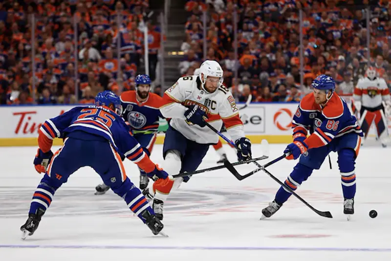 Florida Panthers center Aleksander Barkov (16) skates with the puck defended by Edmonton Oilers defenseman Darnell Nurse (25) and defenseman Philip Broberg (86) in the first period in game three of the 2024 Stanley Cup Final at Rogers Place. Mandatory Credit: Perry Nelson-USA TODAY Sports