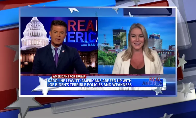 Video still from Real America on One America News Network showing a split screen of the host on the left side, and on the right side is the guest, Karoline Leavitt.