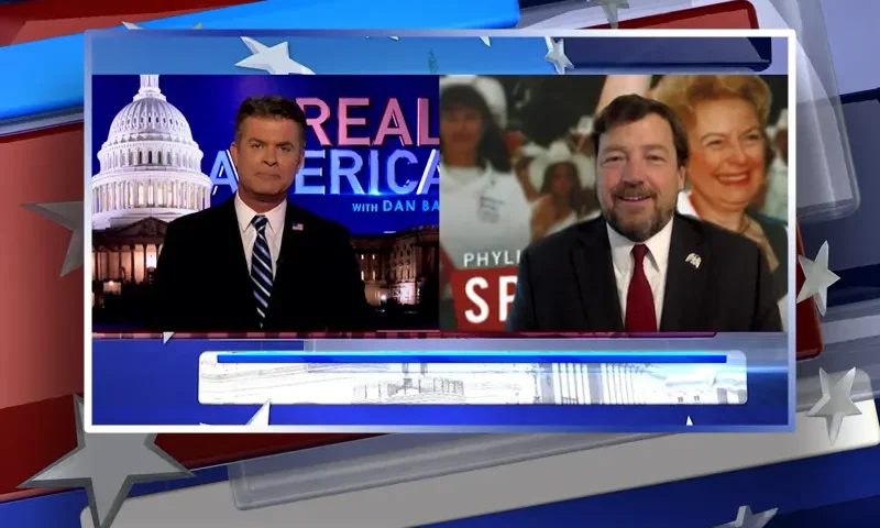 Video still from Real America on One America News Network showing a split screen of the host on the left side, and on the right side is the guest, Ed Martin.