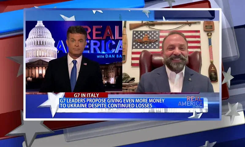 Video still from Real America on One America News Network showing a split screen of the host on the left side, and on the right side is the guest, Chad Robichaux.
