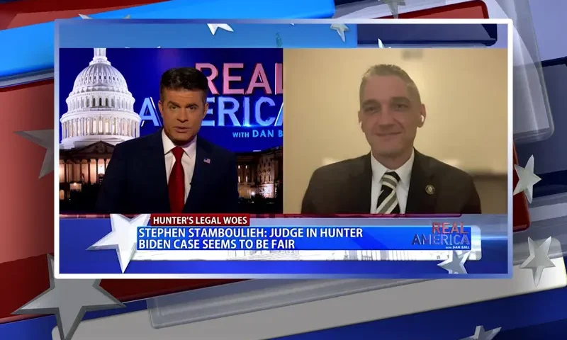 Video still from Real America on One America News Network showing a split screen of the host on the left side, and on the right side is the guest, Stephen Stamboulieh.