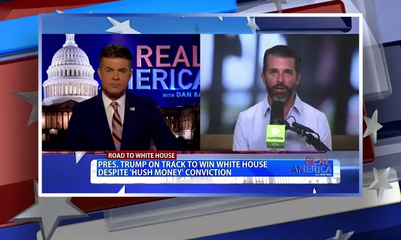 Video still from Real America on One America News Network showing a split screen of the host on the left side, and on the right side is the guest, Donald Trump Jr..