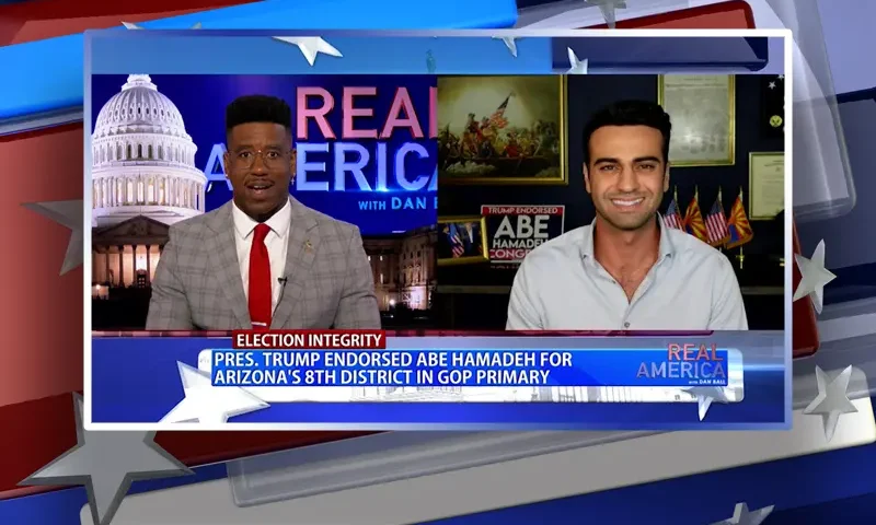Video still from Real America on One America News Network showing a split screen of the host on the left side, and on the right side is the guest, Abe Hamadeh.