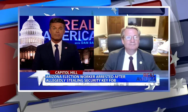 Video still from Real America on One America News Network showing a split screen of the host on the left side, and on the right side is the guest, Rep. Tim Burchett.