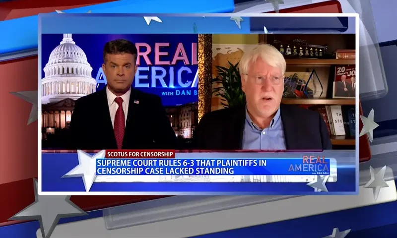 Video still from Real America on One America News Network showing a split screen of the host on the left side, and on the right side is the guest, Joe Hoft.