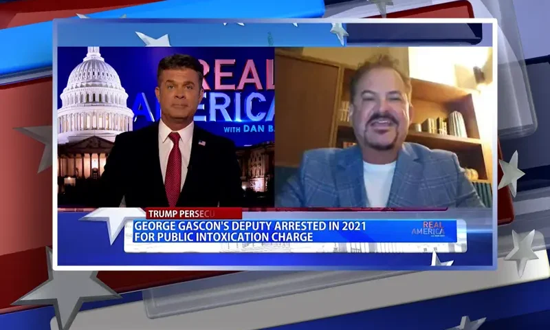 Video still from Real America on One America News Network showing a split screen of the host on the left side, and on the right side is the guest, David Wohl.