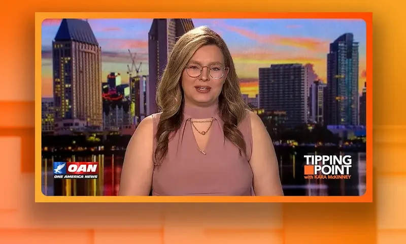 Video still of the host of Tipping Point at the desk of their talk show on One America News Network.
