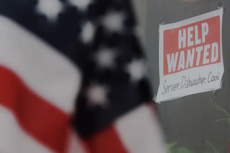 A “Help Wanted” sign hangs in restaurant window in Medford, Massachusetts, U.S., January 25, 2023. REUTERS/Brian Snyder