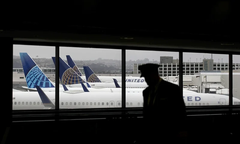 SAN FRANCISCO, CALIFORNIA - APRIL 12: A pilot walks by United Airlines planes as they sit parked at gates at San Francisco International Airport on April 12, 2020 in San Francisco, California. San Francisco International Airport has a seen a huge decline in daily flights since the coronavirus shelter in place. United Airlines, the airport's largest carrier with the most daily flights with 290 flights per day before the start of the COVID-19 pandemic, has reduced their daily flights to 50 per day. (Photo by Justin Sullivan/Getty Images)