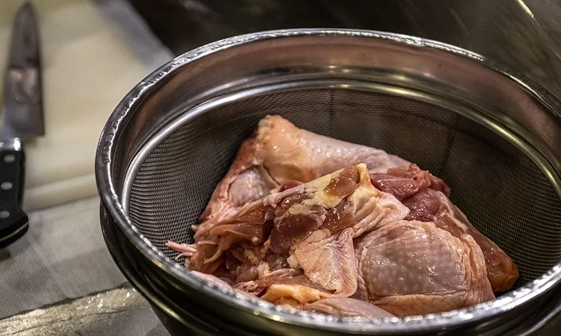 This picture taken on March 1, 2023 shows raw chicken being prepared at an izakaya bar in Tokyo. - Munching their way through hundreds of golden-brown morsels, a team of judges searched relentlessly to find the ultimate "karaage" -- the fried chicken known as "Japan's comfort food". (Photo by Philip FONG / AFP) / To go with "Japan-food-drink-lifestyle-business-chicken", FOCUS by Andrew MCKIRDY (Photo by PHILIP FONG/AFP via Getty Images)