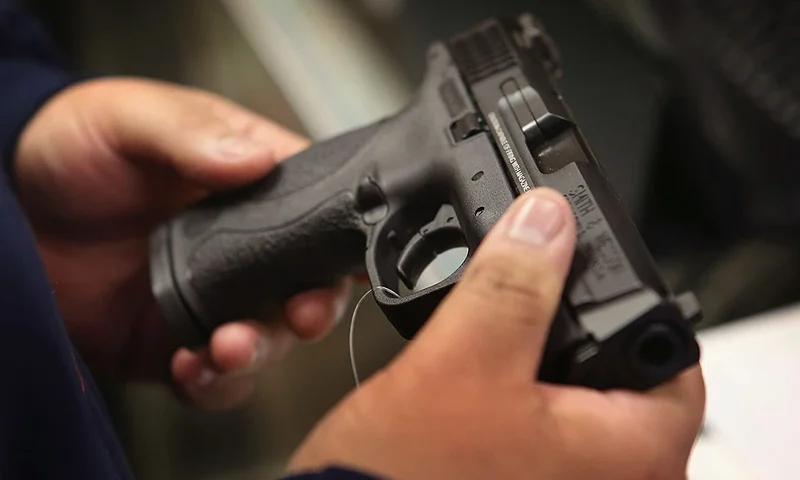 TINLEY PARK, IL - DECEMBER 17: A customer shops for a pistol at Freddie Bear Sports sporting goods store on December 17, 2012 in Tinley Park, Illinois. (Photo by Scott Olson/Getty Images)