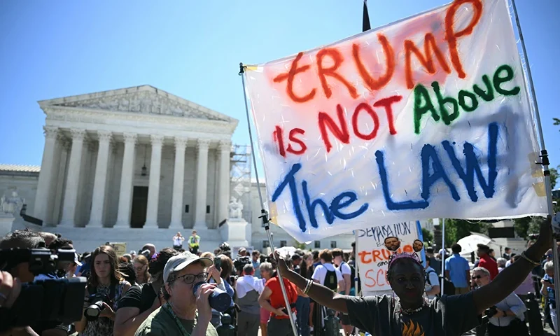 TOPSHOT - People hold anti Trump signs in front of the US Supreme Court on July 1, 2024, in Washington, DC. Donald Trump on Monday hailed a "big win" for democracy after the US Supreme Court ruled that presidents have presumptive immunity for official acts -- a decision set to delay his trial for conspiring to overturn his 2020 election loss. (Photo by Drew ANGERER / AFP) (Photo by DREW ANGERER/AFP via Getty Images