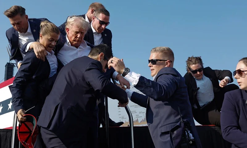 BUTLER, PENNSYLVANIA - JULY 13: Republican presidential candidate former President Donald Trump is rushed offstage by U.S. Secret Service agents after being grazed by a bullet during a rally on July 13, 2024 in Butler, Pennsylvania. Butler County district attorney Richard Goldinger said the shooter is dead after injuring former U.S. President Donald Trump, killing one audience member and injuring another in the shooting. (Photo by Anna Moneymaker/Getty Images)