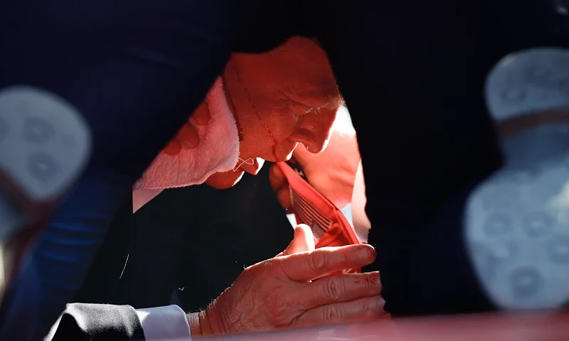 Donald Trump Holds A Campaign Rally In Butler, Pennsylvania BUTLER, PENNSYLVANIA - JULY 13: Secret Service tend to republican presidential candidate former President Donald Trump onstage after he was grazed by a bullet at a rally on July 13, 2024 in Butler, Pennsylvania. Butler county district attorney Richard Goldinger said the shooter is dead after injuring former President Trump, killing one audience member and injuring another in the shooting. (Photo by Anna Moneymaker/Getty Images)