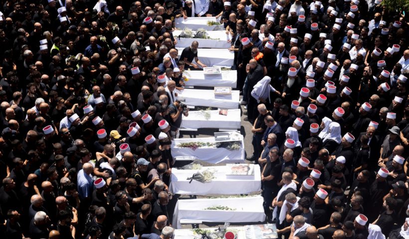 GOLAN HEIGHTS, - JULY 28: Mourners attend a funeral held for 10 of the victims of yesterday's rocket attack on July 28, 2024 in Majdal Shams, Golan Heights. Yesterday, 12 young people were killed in a rocket attack on a football pitch in this Druze Arab community. Israel blamed the militant group Hezbollah, with which it has been regularly exchanging fire across the Lebanese border, although the group denied responsibility. Today, Israel said it had retaliated with strikes against Hezbollah targets "deep inside Lebanese territory." (Photo by Amir Levy/Getty Images)