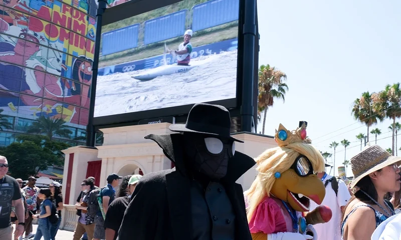 US-ENTERTAINMENT-FILM-FESTIVAL-CARTOON-COMICCON The Olympic games are seen on a giant screen as attendees walk to the convention center during Comic Con International in San Diego, California, July 28, 2024. (Photo by Chris DELMAS / AFP) (Photo by CHRIS DELMAS/AFP via Getty Images)