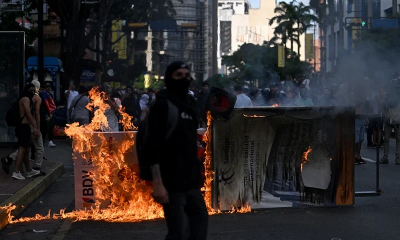 VENEZUELA-ELECTION-VOTE-AFTERMATH-PROTEST Demonstrators set a barricade on fire during a protest against Venezuelan President Nicolas Maduro's government in Caracas on July 29, 2024, a day after the Venezuelan presidential election. Protests erupted in parts of Caracas Monday against the re-election victory claimed by Venezuelan President Nicolas Maduro but disputed by the opposition and questioned internationally, AFP journalists observed. (Photo by JUAN BARRETO / AFP) (Photo by JUAN BARRETO/AFP via Getty Images)