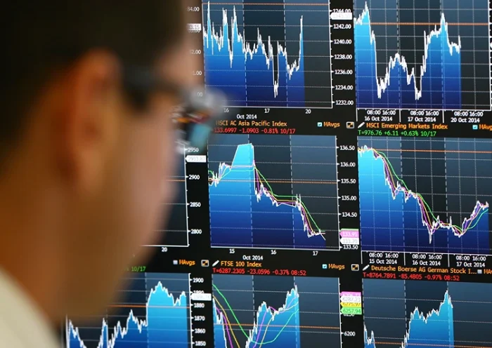 Markets Stabilise After Turbulence Last Week LONDON, ENGLAND - OCTOBER 20: An employee views trading screens at the offices of Panmure Gordon and Co on October 20, 2014 in London, England. Markets stabilised over the weekend following global turbulence amid fears over the Ebola virus and global economic concerns. (Photo by Carl Court/Getty Images)