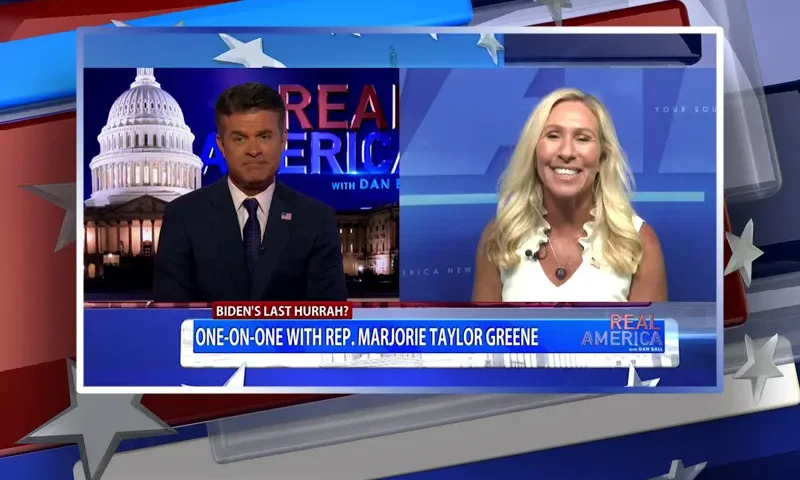 Video still from Real America on One America News Network showing a split screen of the host on the left side, and on the right side is the guest, Rep. Marjorie Taylor Greene.