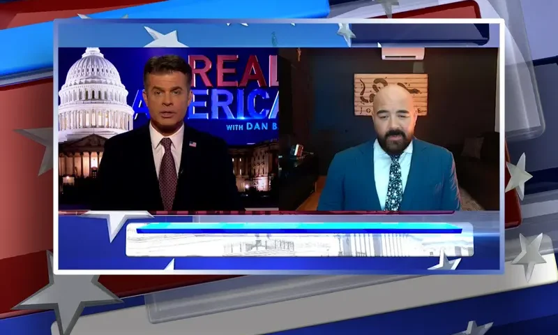 Video still from Real America on One America News Network showing a split screen of the host on the left side, and on the right side is the guest, Joseph McBride.