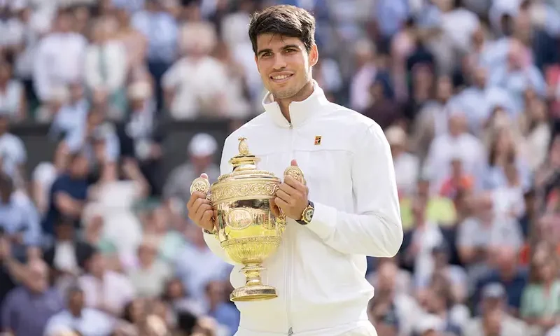 Carlos Alcaraz of Spain poses with the trophy after winning the menÕs singles match against Novak Djokovic of Serbia on day 14 at All England Lawn Tennis and Croquet Club. Mandatory Credit: Susan Mullane-USA TODAY Sports