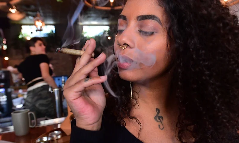 Kush Doleo smokes a joint at the Lowell Cafe in West Hollywood, California, on September 30, 2019, a day before its official opening. - America's first cannabis restaurant has opened in West Hollywood, offering diners an array of weed products and hoping to rival Amsterdam's famed coffee shops. Called Lowell Farms: A Cannabis Cafe, the much-hyped 240-seat establishment is open to people 21 and over, who can order from a cannabis menu just like they would a wine bottle. (Photo by Frederic J. BROWN / AFP) (Photo by FREDERIC J. BROWN/AFP via Getty Images)