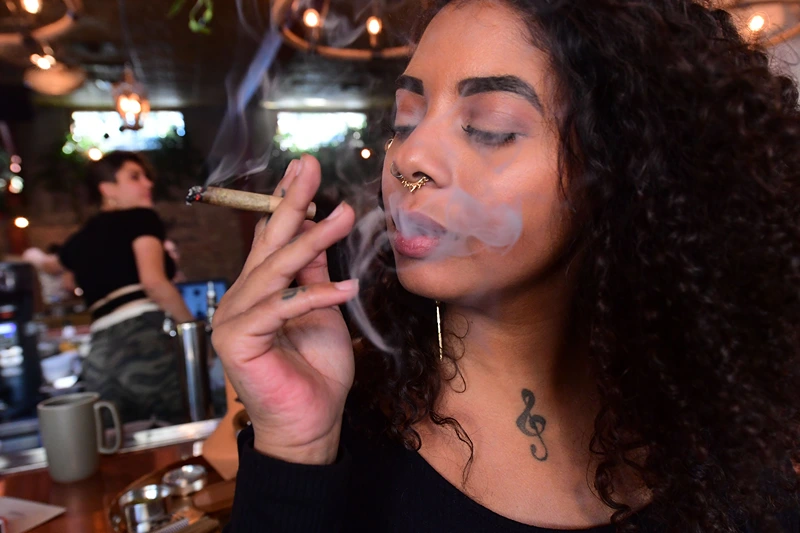 Kush Doleo smokes a joint at the Lowell Cafe in West Hollywood, California, on September 30, 2019, a day before its official opening. - America's first cannabis restaurant has opened in West Hollywood, offering diners an array of weed products and hoping to rival Amsterdam's famed coffee shops. Called Lowell Farms: A Cannabis Cafe, the much-hyped 240-seat establishment is open to people 21 and over, who can order from a cannabis menu just like they would a wine bottle. (Photo by Frederic J. BROWN / AFP) (Photo by FREDERIC J. BROWN/AFP via Getty Images)