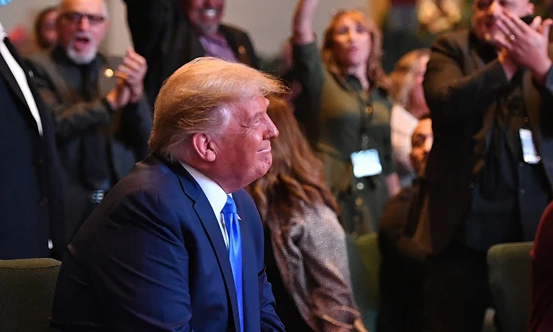 TOPSHOT - US President Donald Trump(L) smiles as he attends services at the International Church of Las Vegas in Las Vegas, Nevada, where he was cheered on by church members on October 18, 2020. President Donald Trump and rival Joe Biden hit the ground Sunday in the swing states that will decide the US election, as the campaign turns increasingly vicious 16 days before voting. Trump, scrambling to make up lost ground, is on a furious multi-state barnstorming tour hopping from Nevada to California and then back to Nevada for a day of rallies and fundraising. (Photo by MANDEL NGAN / AFP) (Photo by MANDEL NGAN/AFP via Getty Images)