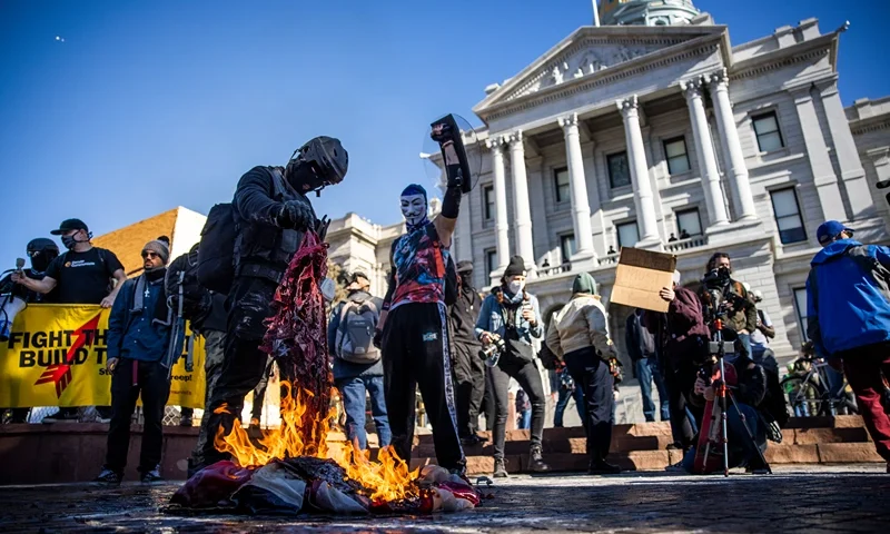 DENVER, CO - JANUARY 20: Members of the Communist Party USA and other anti-fascist groups burn an American flag on the steps of the Colorado State Capitol on January 20, 2021 in Denver, Colorado. Joe Biden was sworn in as the 46th President of the United States with Vice President Kamala Harris at an inauguration ceremony in Washington DC earlier in the day. (Photo by Michael Ciaglo/Getty Images)