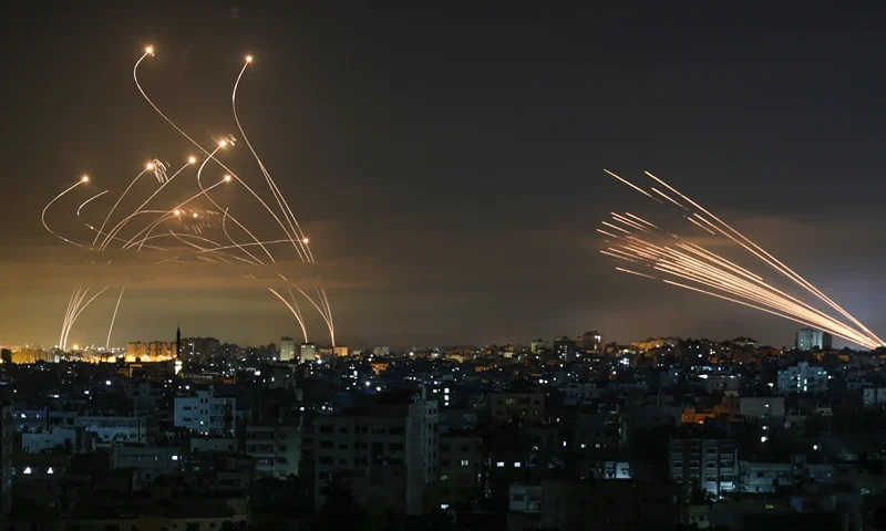 TOPSHOT - The Israeli Iron Dome missile defence system (L) intercepts rockets (R) fired by the Hamas movement towards southern Israel from Beit Lahia in the northern Gaza Strip as seen in the sky above the Gaza Strip overnight on May 14, 2021. Israel bombarded Gaza with artillery and air strikes on Friday, May 14, in response to a new barrage of rocket fire from the Hamas-run enclave, but stopped short of a ground offensive in the conflict that has now claimed more than 100 Palestinian lives. As the violence intensified, Israel said it was carrying out an attack "in the Gaza Strip" although it later clarified there were no boots on the ground. (Photo by ANAS BABA / AFP) (Photo by ANAS BABA/AFP via Getty Images)